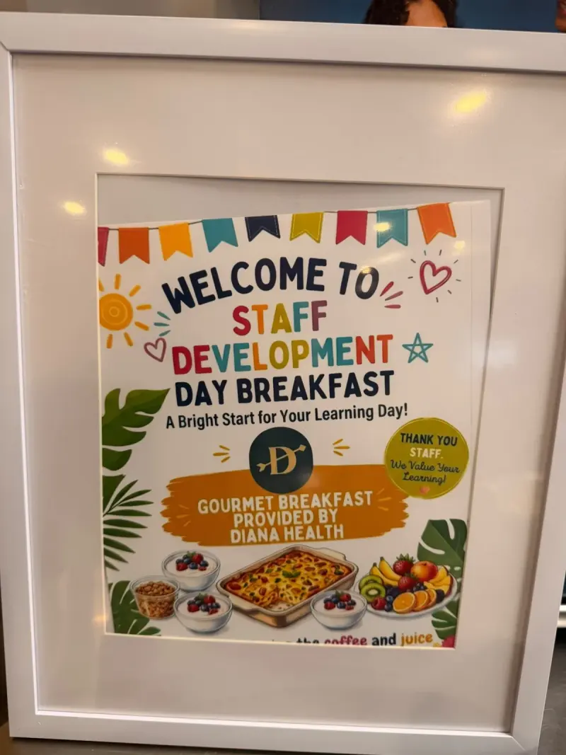 A framed “Welcome to Staff Development Day Breakfast” sign with coloured bunting: “A bright start for your learning day! Gourmet breakfast provided by Diana Health”